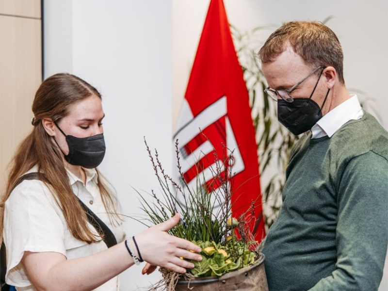 Katharina Karg übergibt LR Christian Gantner einen Frühlingsgruß